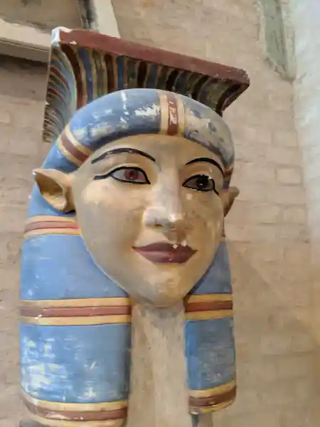 Painted Egyptian column capital depicting the face and headdress of a goddess Hathor
